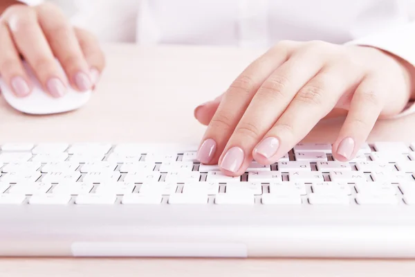 Manos femeninas escribiendo en el teclado sobre fondo claro —  Fotos de Stock