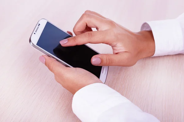 Frau benutzt Smartphone auf hellem Hintergrund — Stockfoto