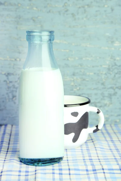 Retro fles en mok van smakelijke melk, op tafel — Stockfoto