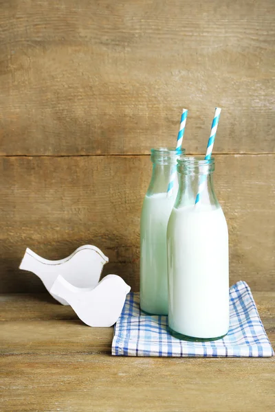 Retro bottles of tasty rustic milk, on wooden table — Stock Photo, Image