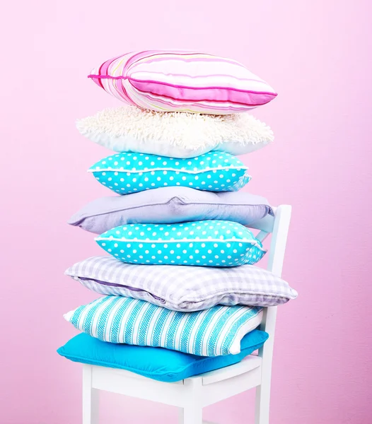 Bright pillows on chair in room on pink background — Stock Photo, Image