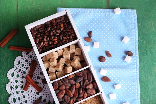 Caja de madera con set de café y granos de cacao, terrones de azúcar sobre fondo de madera — Foto de Stock