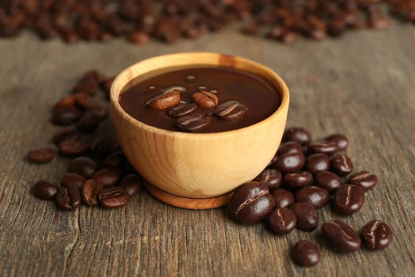 Kopi kacang dengan coklat glaze pada latar belakang kayu — Stok Foto