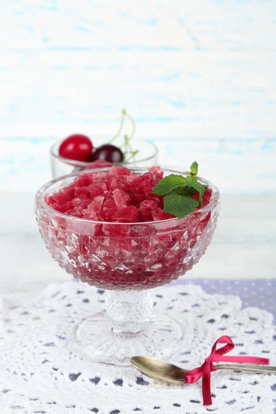 Closeup of cherry granita in glass bowl, on color wooden background — Stock Photo, Image