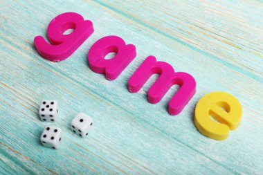 Ahşap arka plan üzerinde renkli harflerle oyun kelime oluşan