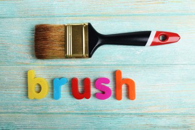 Ahşap arka plan üzerinde renkli harflerle fırça word kurdu