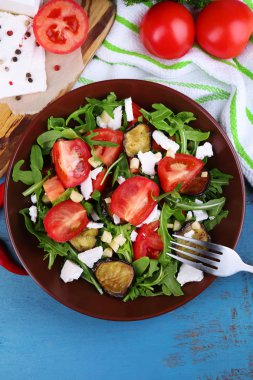 Patlıcan salata domates, roka ve beyaz peynir, peçeteye renk ahşap arka plan üzerinde