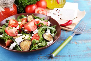 Patlıcan salata domates, roka ve beyaz peynir, peçeteye renk ahşap arka plan üzerinde