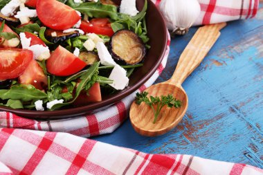 Patlıcan salata domates, roka ve beyaz peynir, peçeteye renk ahşap arka plan üzerinde