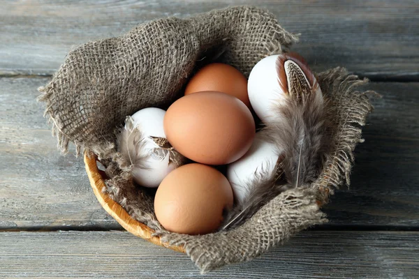 Eggs in basket, on wooden background. Organic food concept — Stock Photo, Image