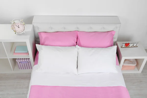 Белая кровать с розовым чехлом — стоковое фото