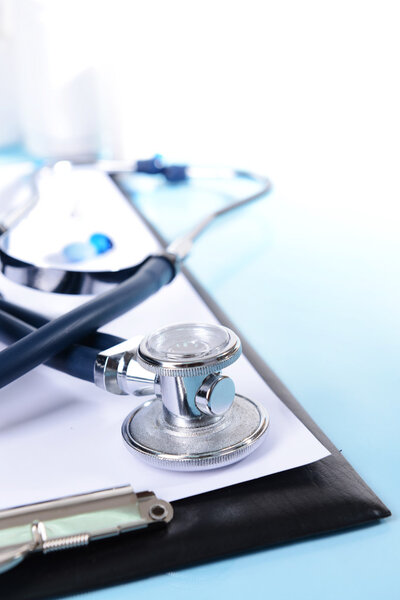 Stethoscope on light blue background