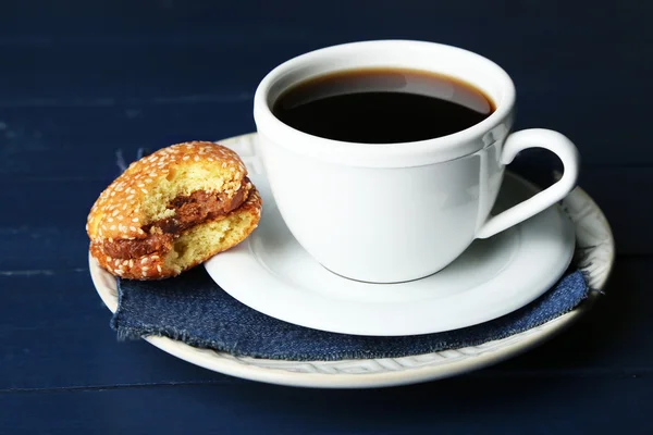 Filiżanka kawy z smaczne ciasteczko na kolor drewniane tła — Zdjęcie stockowe