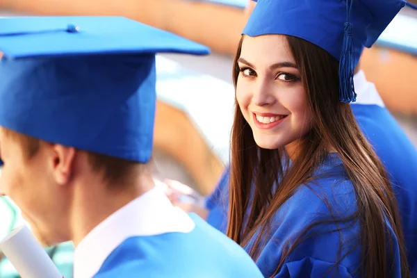 Estudiantes de postgrado con sombrero y bata de graduación, al aire libre —  Fotos de Stock