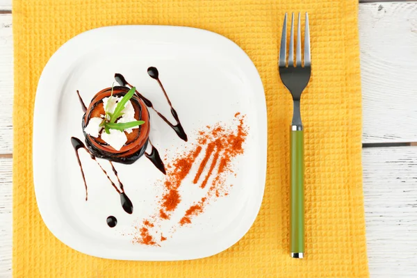 Insalata di melanzane con pomodoro e formaggio feta su piatto, su fondo di legno — Foto Stock