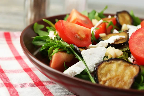 Salade d'aubergines aux tomates, roquette et fromage feta, sur serviette, sur fond de bois couleur — Photo