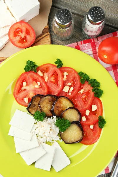 Salade d'aubergines aux tomates et fromage feta, sur serviette, sur fond bois — Photo