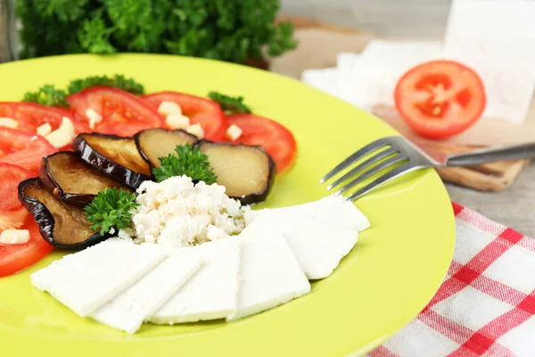 Salade d'aubergines aux tomates et fromage feta, sur serviette, sur fond bois — Photo