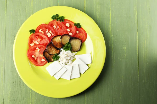 Lilku salát s rajčaty a sýrem feta, na dřevěné pozadí — Stock fotografie