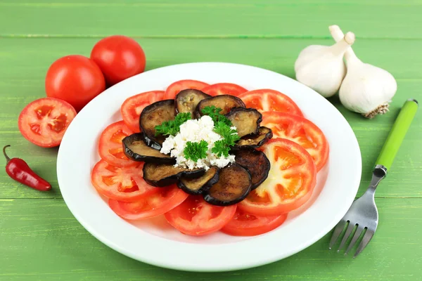 Auberginen-Salat mit Tomaten und Feta-Käse, auf Holzgrund — Stockfoto