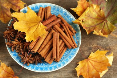 Tarçın sopa ve anason ahşap zemin üzerine sarı yaprakları ile yıldız