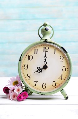 Açık mavi renkli masaya saati ile güzel çiçekler