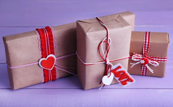 Три подарочных коробки на деревянном фоне — стоковое фото