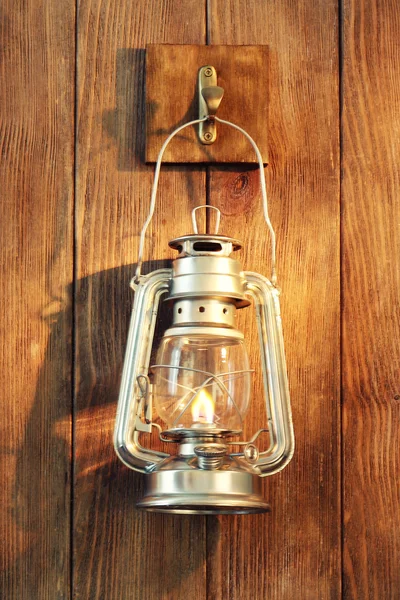 Lantern hanging on hook on wooden wall — Stock Photo, Image