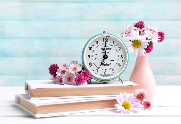 Lindas flores em vaso na mesa no fundo azul claro — Fotografia de Stock