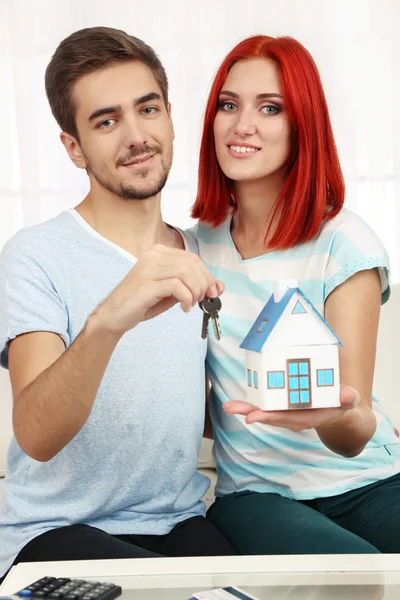 Loving couple sitting in sofa — Stock Photo, Image