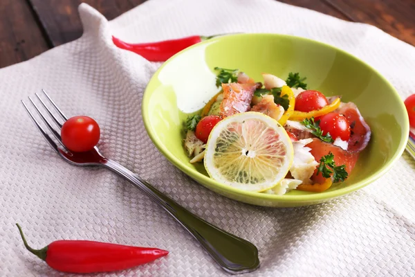 Ensalada de pescado apetitoso con verduras en el plato en primer plano de la mesa —  Fotos de Stock