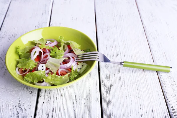 Frischer Fischsalat mit Gemüse auf Teller auf Holztisch in Großaufnahme — Stockfoto