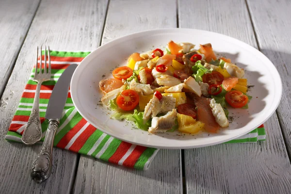 Insalata di pesce fresca con verdure su piatto su tavolo di legno primo piano — Foto Stock