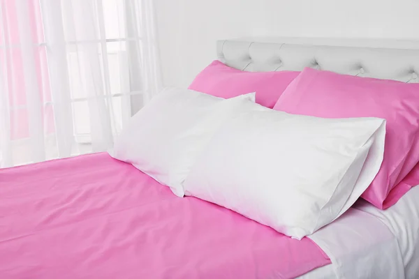 Cama en ropa de cama rosa — Foto de Stock