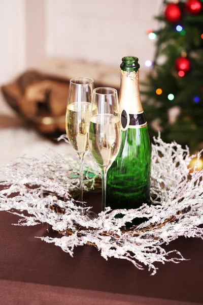 Christmas decorations and champagne bottle and glasses on bright background — Stock Photo, Image