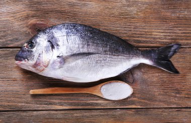 Taze balık ve ahşap zemin üzerine kaşık tuz