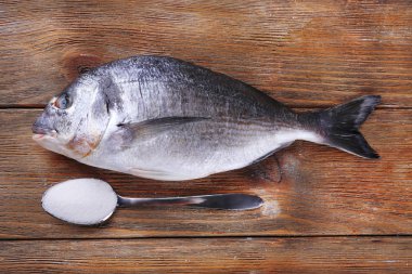Taze balık ve ahşap zemin üzerine kaşık tuz