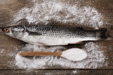 Taze balık ve ahşap zemin üzerine kaşık tuz