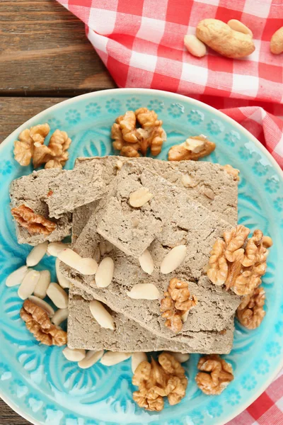 Halva de girassol com nozes na placa, no fundo de madeira — Fotografia de Stock