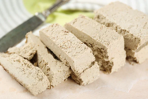 Sunflower halva on cutting board, on wooden background — Stock Photo, Image