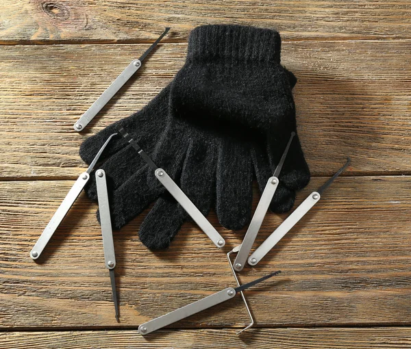 Lock picks met handschoenen op houten tafel — Stockfoto