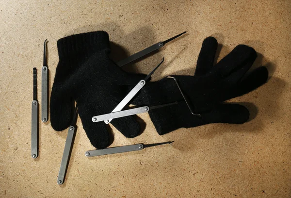 Escoge cerradura con guantes en mesa de madera —  Fotos de Stock