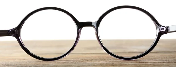 Brýle na dřevěný stůl na bílém pozadí — Stock fotografie
