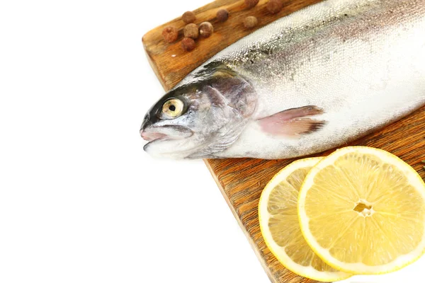 Свежая сырая рыба на разделочной доске и пищевые ингредиенты, изолированные на белом — стоковое фото