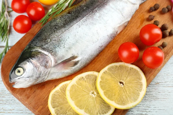 Färsk rå fisk och livsmedelsingredienser på bord — Stockfoto