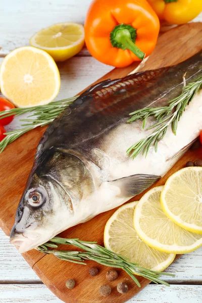 Fresh raw fish and food ingredients on table — Stock Photo, Image