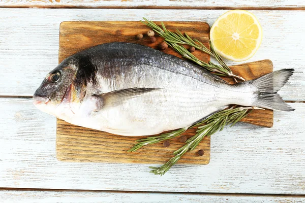 Verse rauwe vis en voedselingrediënten op tafel — Stockfoto