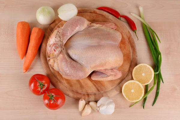 Сырая курица с овощами на столе — стоковое фото