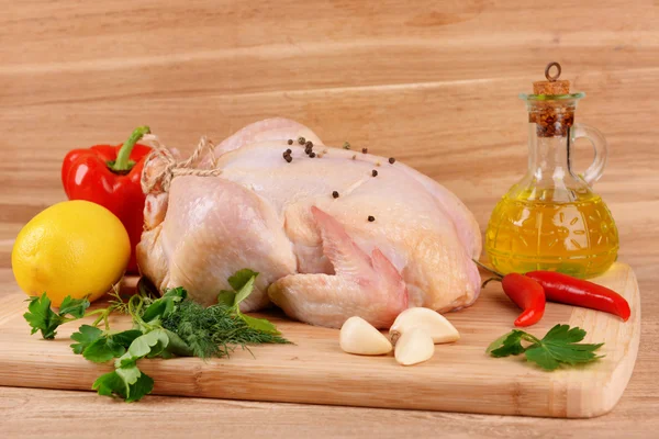 Raw chicken on wooden table — Stock Photo, Image