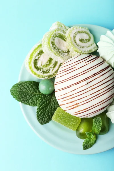 Merengues de color menta, caramelos de menta y sabroso pastel en el fondo de color —  Fotos de Stock